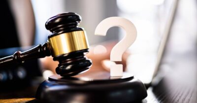 A gavel and a question mark on a desk. | Klein Lawyers