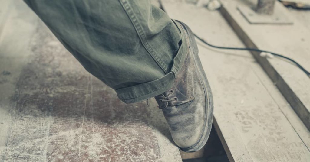 man's foot caught in between floor boards of dangerous premises