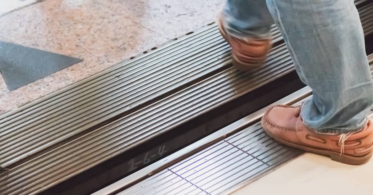 feet of man walking over uneven threshold in a dangerous building