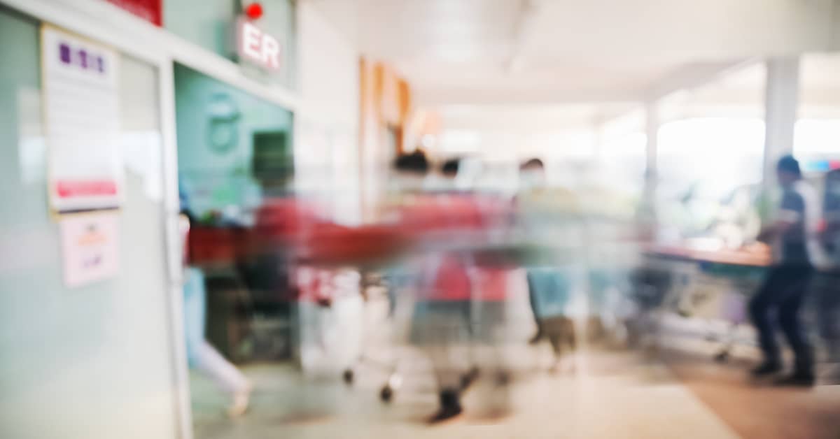 medical professionals hurrying a patient on a hospital gurney into the emergency room