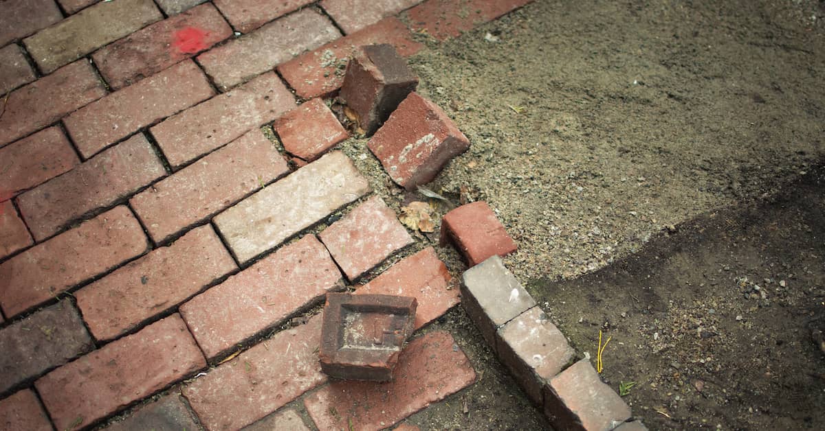 broken bricks creating a tripping hazard on brick sidewalk