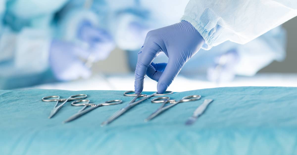 doctor reaching for surgical instruments during operation